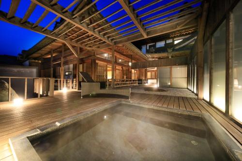 富士河口湖富士温泉寺梦殿日式旅馆的一座带木甲板的建筑中的室内游泳池