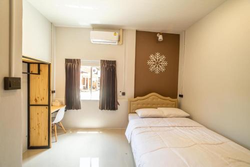 勿洞J Villa Betong - Private House的一间卧室配有一张床、一张书桌和一个窗户。