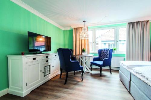 朗格奥Lieblingsinsel Langeoog的卧室设有绿色墙壁和桌椅