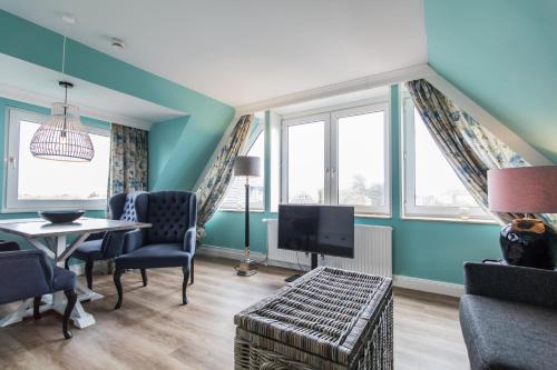 朗格奥Lieblingsinsel Langeoog的客厅设有蓝色的墙壁、桌子和电视。