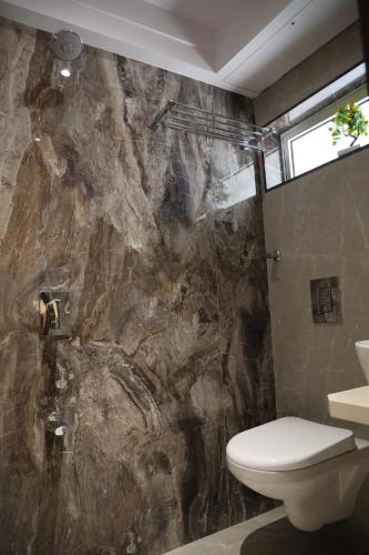 孟买Vishal Hall的一间带卫生间和岩石墙的浴室