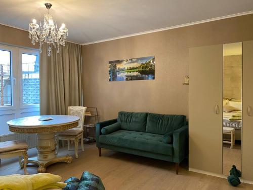 列日Studio Montaigne的客厅配有绿色沙发和桌子