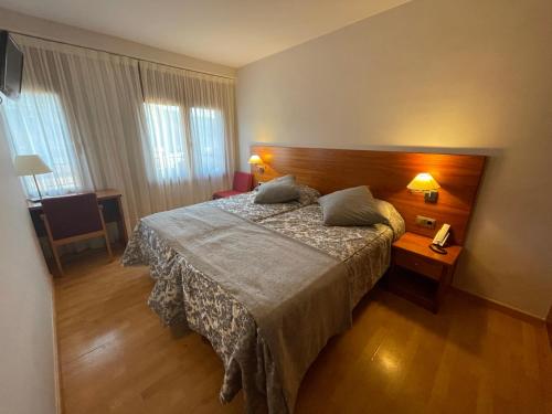 La Pobleta de Bellvei阿图罗酒店的酒店客房配有一张床、一张桌子和一部电话