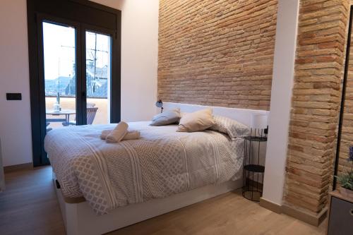 维克Niu del Sol的一间卧室设有一张床和砖墙