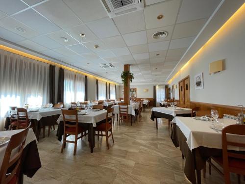 La Pobleta de Bellvei阿图罗酒店的一间设有白色桌椅的用餐室