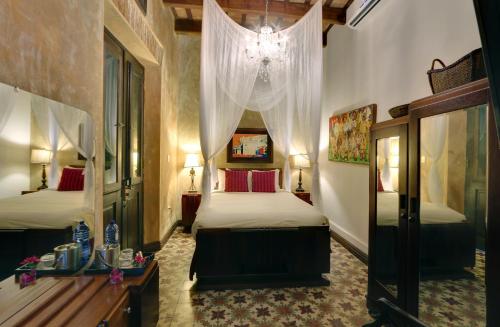 圣胡安埃伦西亚别墅酒店的一间卧室配有两张床和吊灯。