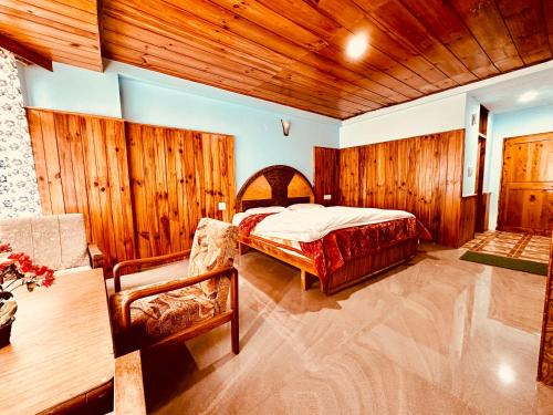 马拉里Hotel D Kanchan Manali的一间卧室设有一张床和木墙