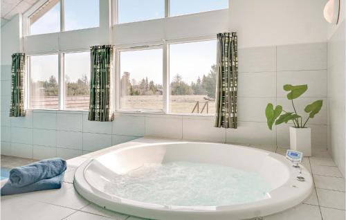 奥贝克博森班瑞度假屋的带窗户的浴室内的白色大浴缸