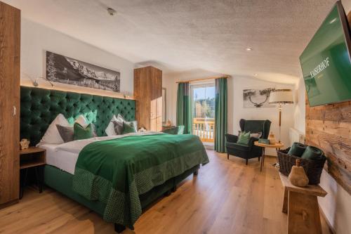 蒂罗尔-泽费尔德凯撒霍夫维塔酒店的酒店客房设有一张绿色的床和一个阳台。