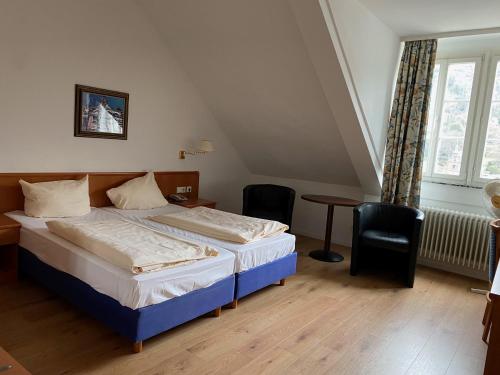 海德堡四季饭店的一间卧室配有一张床、一张桌子和一个窗户。