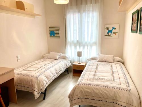 科尔多瓦Apartamento Zoco Córdoba的一间卧室设有两张床和窗户。