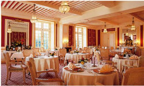 格里里尼城堡酒店的用餐室配有桌椅和白色桌布