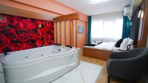 伊斯坦布尔Lukka Suit Hotel的浴室设有墙上红色玫瑰花浴缸。