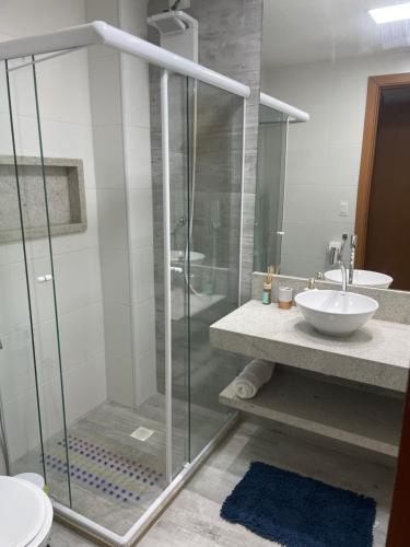 伊塔齐米林Itacimirim Beira Mar的一间带玻璃淋浴和水槽的浴室
