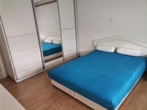图兹拉Apartment holidays and partys with a pool的一间设有蓝色床和镜子的小卧室