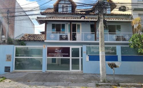 卡波布里奥Zênit Hostel da Cris的蓝色和白色的建筑,设有阳台