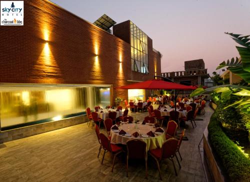 达卡达卡天空之城酒店的大楼前设有桌椅的餐厅