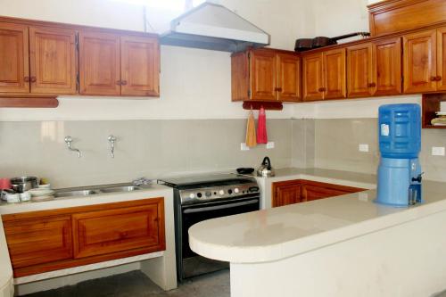比亚米尔港Cielo Azul Galápagos Hotel的厨房配有木制橱柜和炉灶烤箱。