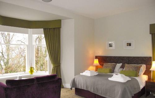 RaasayRaasay House Hotel的一间卧室设有两张床、一张沙发和一个窗口