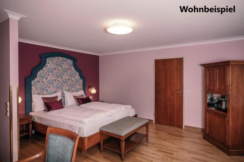巴德伊舍贡德耐奥克斯酒店的一间卧室配有一张大床和一个木制橱柜
