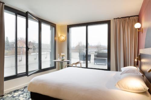 圣西尔-莱科勒ibis Styles Versailles Saint Quentin en Yvelines的酒店客房设有一张床和大窗户