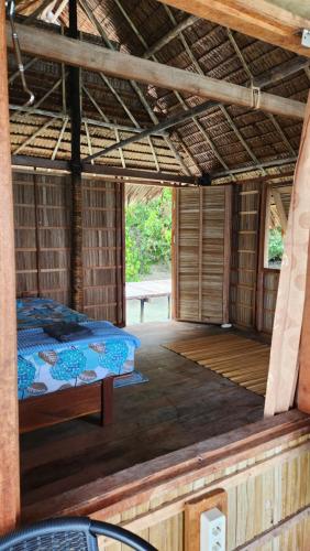 Pulau MansuarTerimakasih homestay的大房间,小屋内有一张床