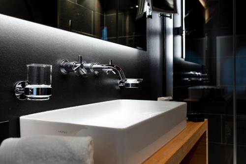 格施塔德Hotel-Restaurant Valrose的浴室设有白色水槽和镜子