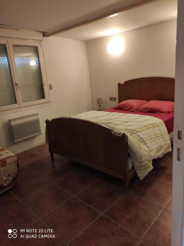 米利拉福雷Maison avec deux chambres au calme的一间卧室配有一张带红色枕头的大床