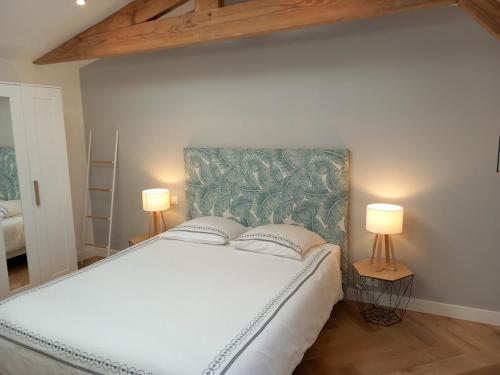 拉布雷德Maison Esprit Des Lois的一间卧室配有一张带两盏灯的大型白色床。