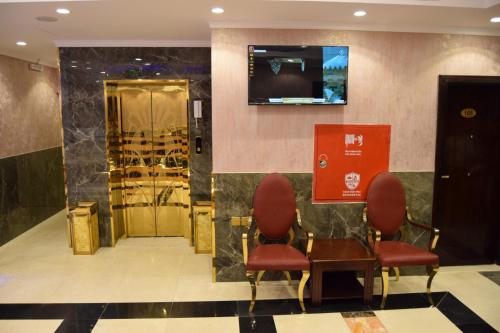 Sīdī Ḩamzahفندق اللؤلؤة الذهبي的一间设有两把椅子和一张桌子的等候室