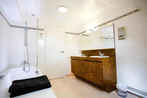 卢瓦尔河畔圣丹尼斯L’Atelier的带浴缸、水槽和淋浴的浴室
