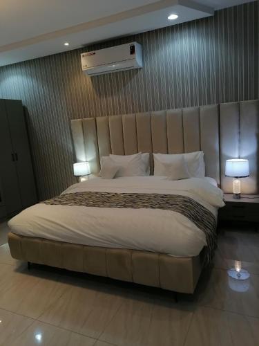 利雅德شقة فاخرة حي الرمال的一张大床,位于酒店带两盏灯的房间