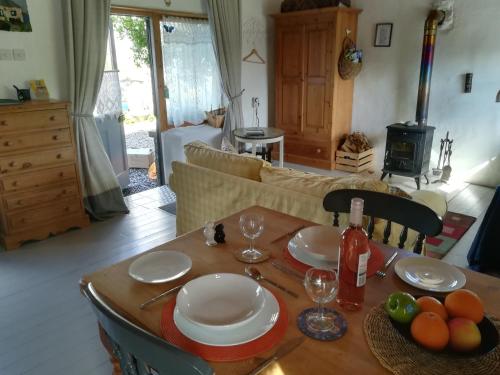 GlendreeDruid cottage的客厅里一张桌子,上面有盘子和玻璃杯
