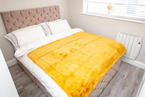 ALBERT COURT的卧室里一张黄色毯子的床