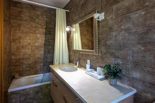 SkalánionRomantic, homely Villa Aura w heated pool的浴室配有盥洗盆和浴缸。