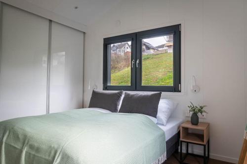 恩基尔希Velo & Wohnen -NEU- Elektroräder inklusive-Sauna-Moselblick的一间卧室设有一张床和两个窗户。