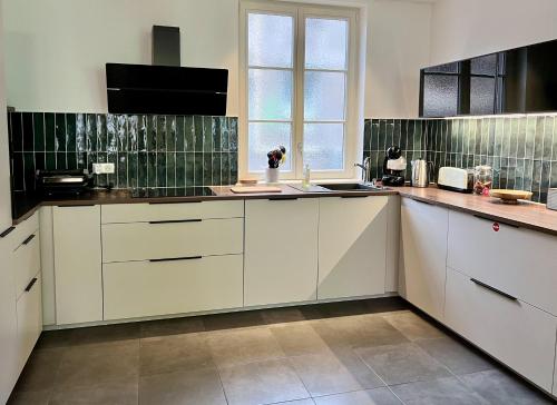阿格诺Centre ville Haguenau - 5pers的厨房配有白色橱柜和窗户。