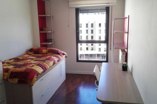 布尔戈斯Grande, luminoso y con garage, 3 dormitorios en el camino de Santiago的一间卧室配有一张床、一张桌子和一个窗户。