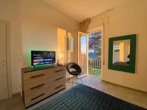 阿尔盖罗Villa Boeddu, relax tra mare e campagna的一间卧室配有带电视和窗户的梳妆台。