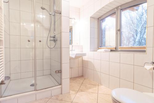 欧巴德伍斯图Dünenhof DÜNENHOF Whg. D-10的带淋浴和盥洗盆的白色浴室