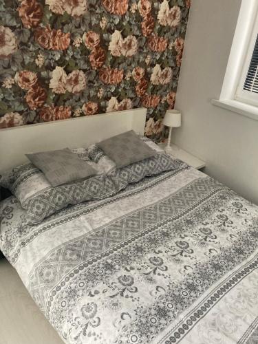 扎布热Apartament Sobieskiego的一间卧室配有一张带花卉墙壁的床