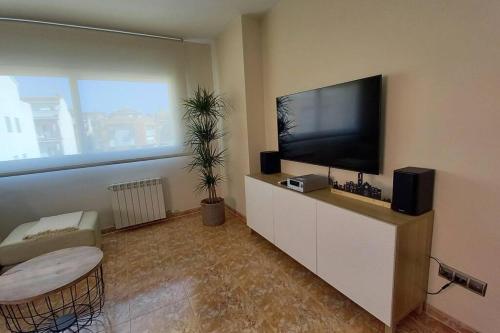 马尔格莱特德玛Atico duplex en Malgrat de Mar的客厅配有壁橱上的平面电视