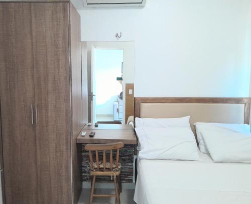 福塔莱萨VG欢乐公寓的一间卧室配有一张床、一张书桌和一面镜子