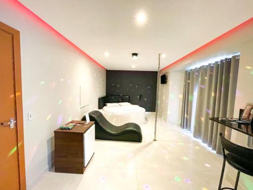 塔瓜汀加Motel Gold的卧室配有一张床,墙上有一条红色条纹