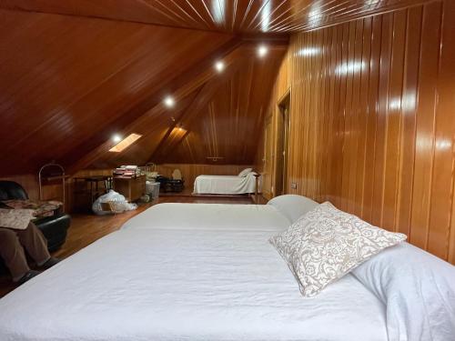拉科鲁尼亚Impresionante casa con parcela en la naturaleza的一张白色大床,位于带木墙的房间