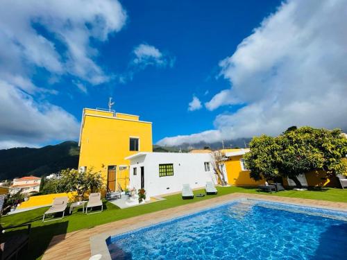 埃尔帕索Vistas directas al volcán y piscina的一座别墅,在一座建筑前设有一个游泳池