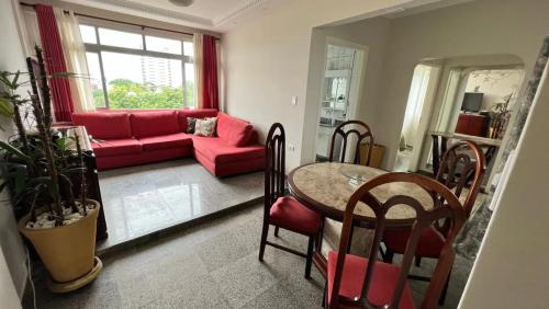圣维森特岛Apartamento no topo da Ilha Porchat的客厅配有红色的沙发和桌子