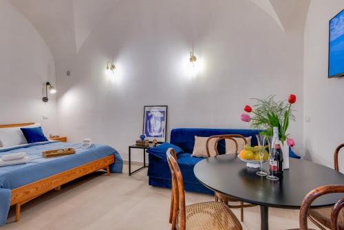 夏卡L'Antro di Dedalo的一间卧室配有一张床和一张带蓝色沙发的桌子