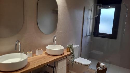 艾扎那扎堡Gaiko Etxe Berri的浴室设有2个水槽、卫生间和镜子。