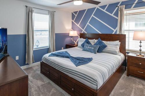 基西米Luxury 9BR Villa @ Storey Lake Resort Near Disney的一间卧室配有一张带蓝色墙壁的大床